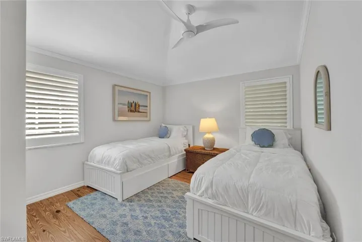 Bedroom with ceiling fan, wood-type flooring, and crown molding