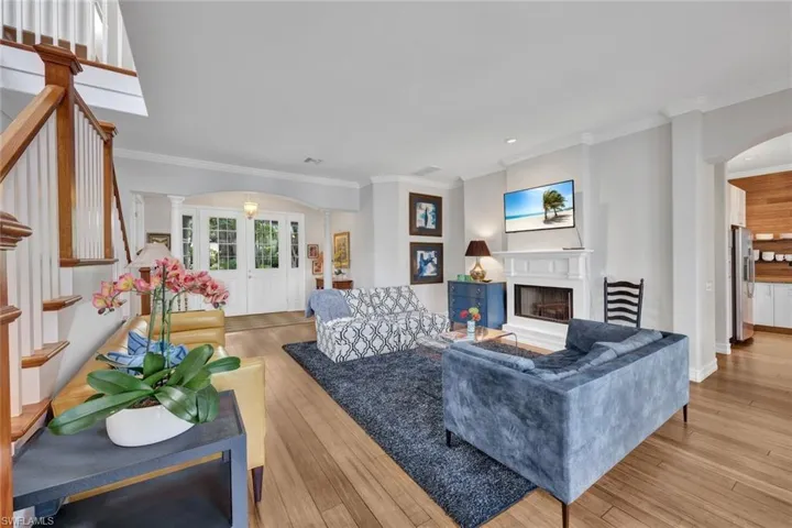 Living room with ornate columns, ornamental molding, and light hardwood / wood-style floors