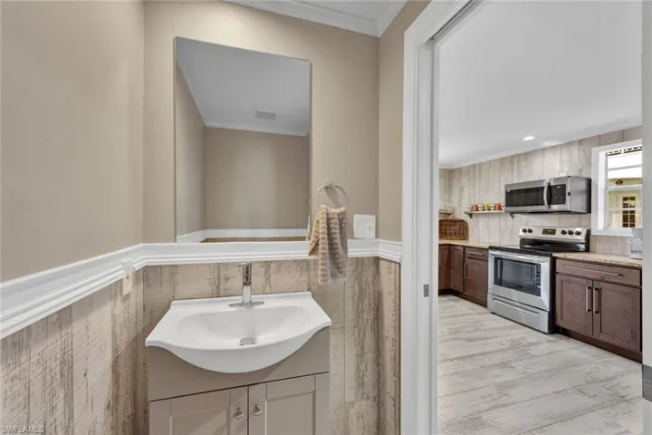 Bathroom featuring crown molding, hardwood / wood-style flooring, and sink