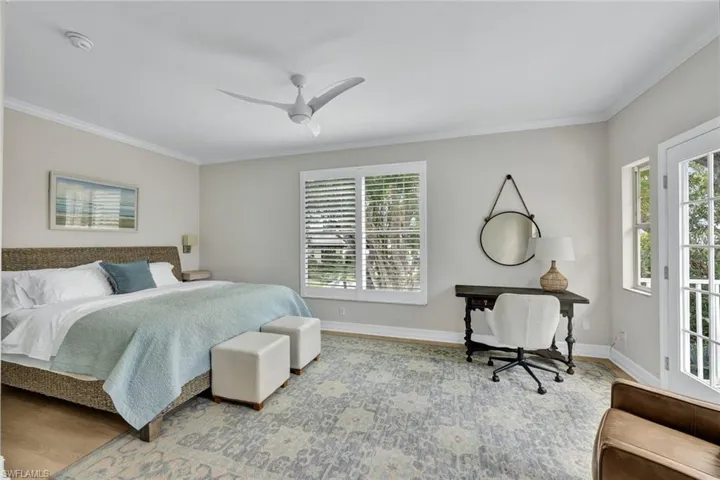 Bedroom with ceiling fan, ornamental molding, and hardwood / wood-style floors