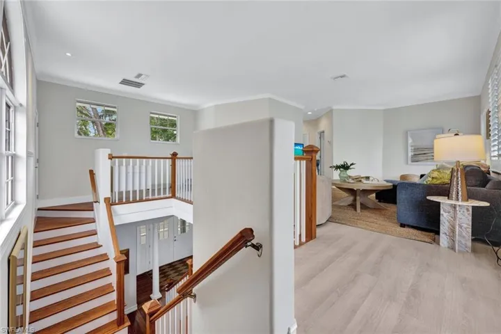 Hallway featuring crown molding and light hardwood / wood-style flooring