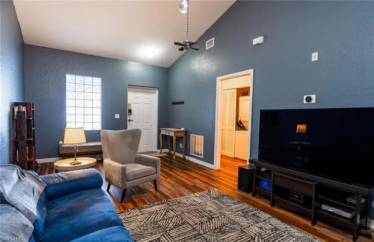 Living room with hardwood / wood-style flooring and vaulted ceiling