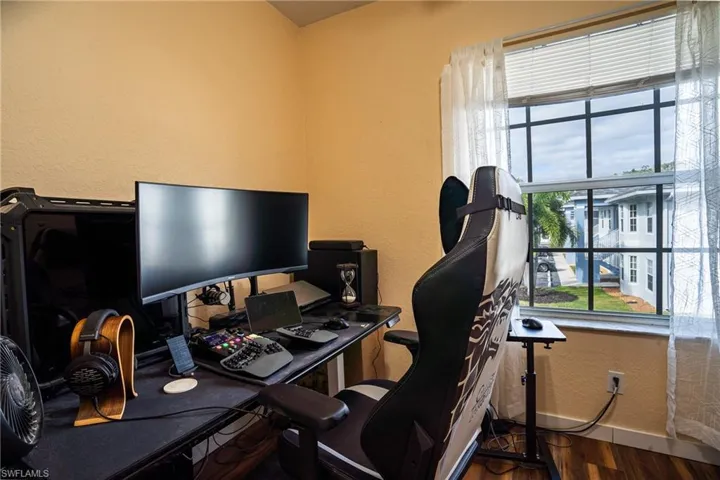 Office space with a healthy amount of sunlight and dark hardwood / wood-style flooring