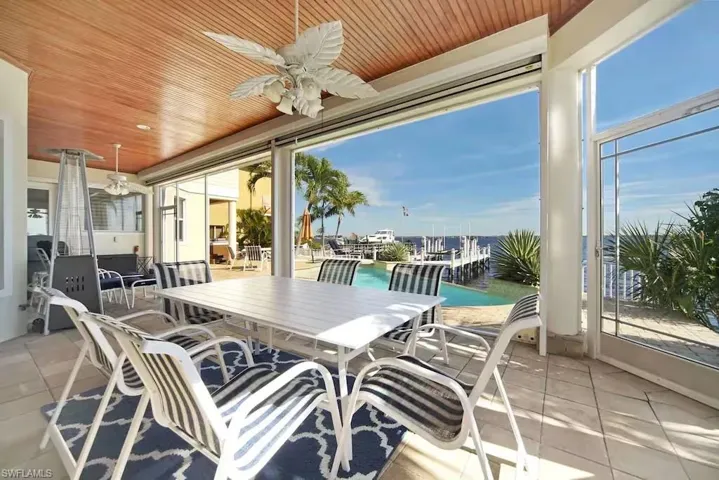 Sunroom featuring wooden ceiling, a water view, and tile patterned flooring