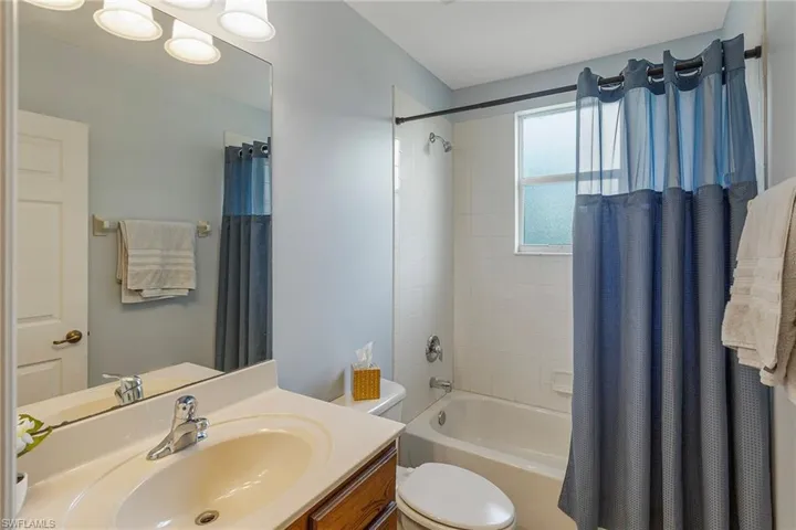 Full bathroom featuring toilet, vanity, and shower / bath combination with curtain