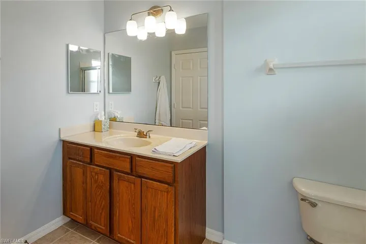 Bathroom featuring vanity, tile patterned floors, and toilet