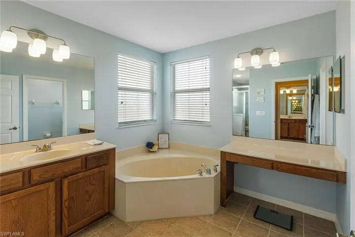 Bathroom with independent shower and bath, vanity, and tile patterned flooring