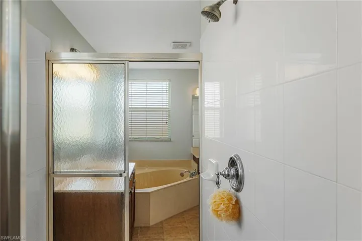 Bathroom featuring independent shower and bath and tile patterned flooring