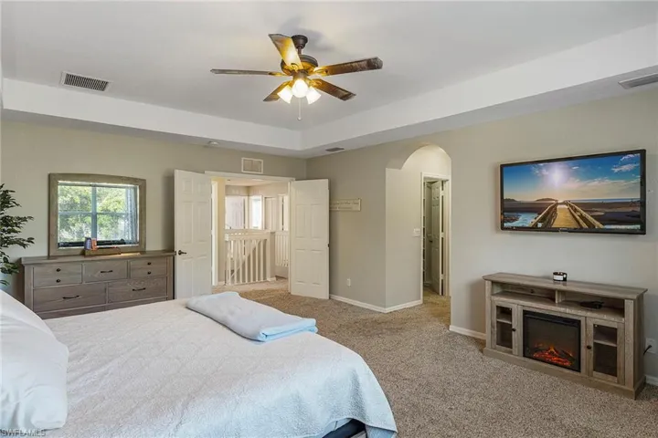 Carpeted bedroom featuring ceiling fan