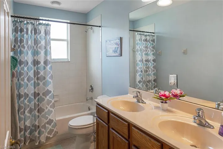 Full bathroom featuring tile patterned flooring, vanity, shower / bathtub combination with curtain, and toilet