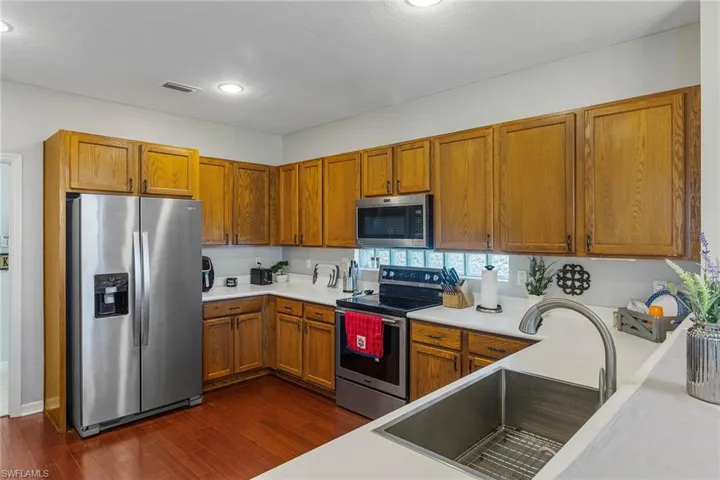 Kitchen featuring a textured ceiling, appliances with stainless steel finishes, dark hardwood / wood-style floors, and sink