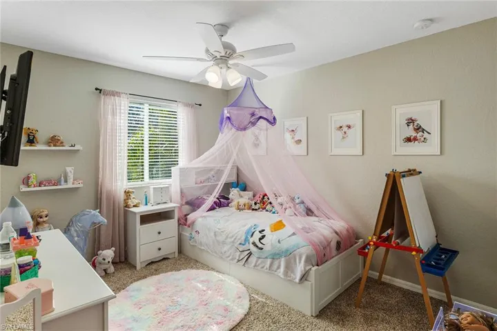 Bedroom featuring light carpet and ceiling fan