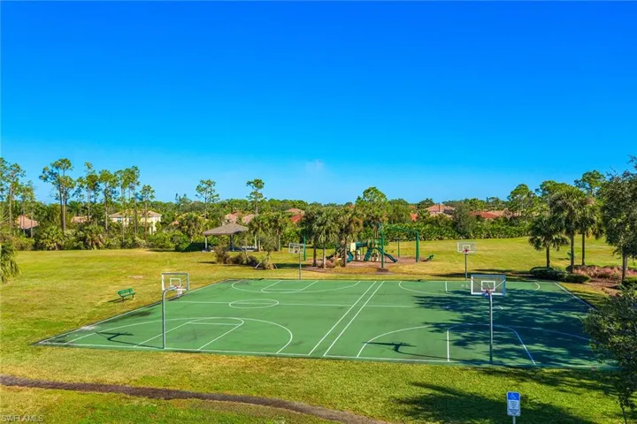 View of sport court featuring a playground and a lawn
