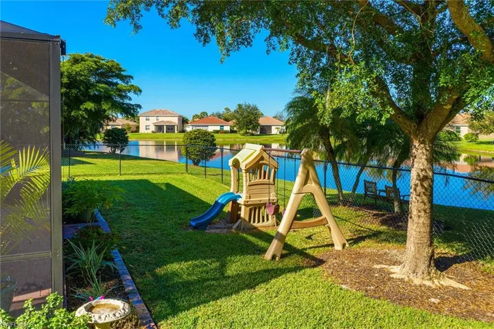 View of jungle gym with a lawn and a water view
