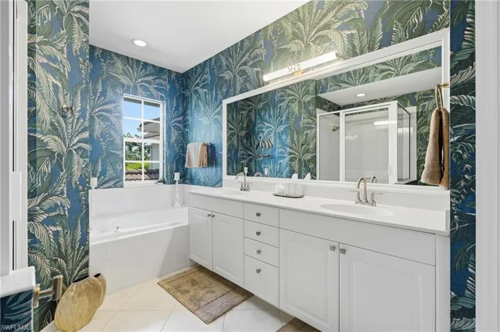 Gorgeous primary ensuite bathroom with dual sinks and custom wallpaper.