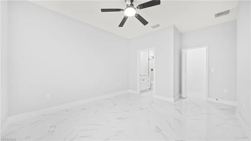 Unfurnished room featuring light marble finish flooring and ceiling fan