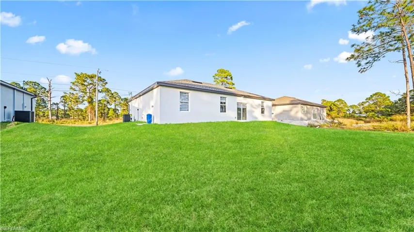 Rear view of house with a yard and stucco siding