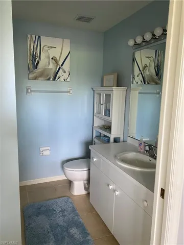 Bathroom with tile floors, oversized vanity, and toilet