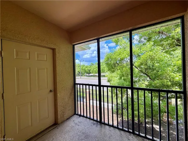 Screened balcony with textured walls and a paneled entry door