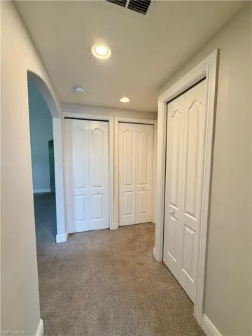 Hallway featuring recessed lighting, light gray wall paint, white trim, and neutral-toned carpeting