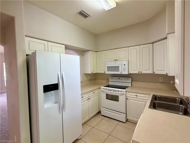 Kitchen featuring white cabinetry, light countertops, and tile flooring