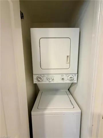 Included stacked washer and dryer unit within a dedicated alcove, featuring a top-loading washing machine and a front-loading dryer