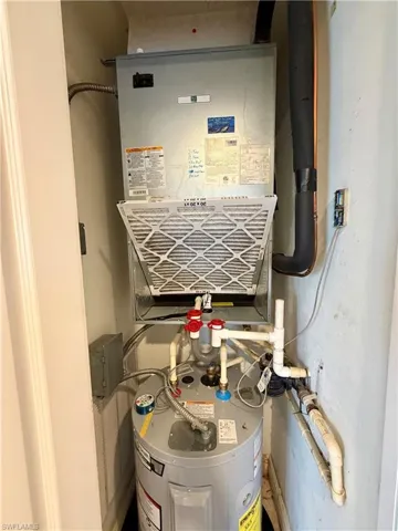 Utility closet featuring a water heater and HVAC unit with visible air filter