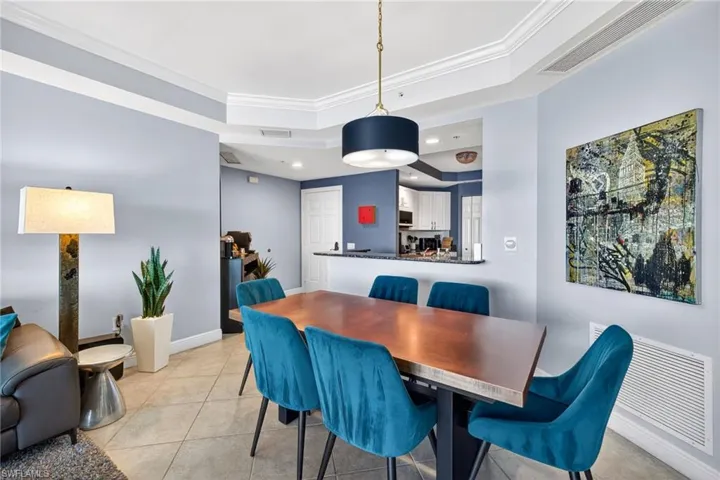Dining area featuring a tray ceiling, crown molding, light tile patterned floors, and recessed lighting