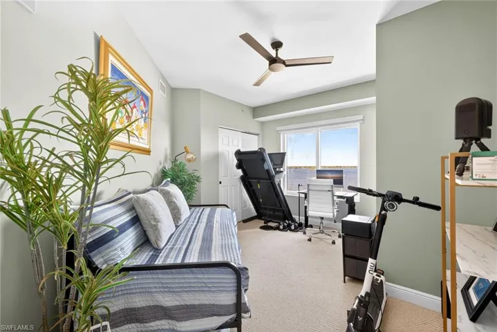 Office area with light carpet and ceiling fan