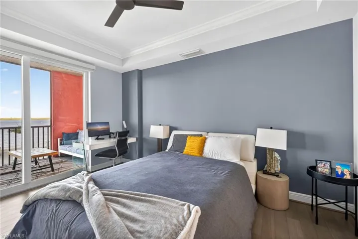 Bedroom featuring hardwood / wood-style floors, access to outside, ceiling fan, ornamental molding, and a desk