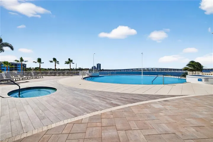 Community pool featuring a community hot tub and a patio