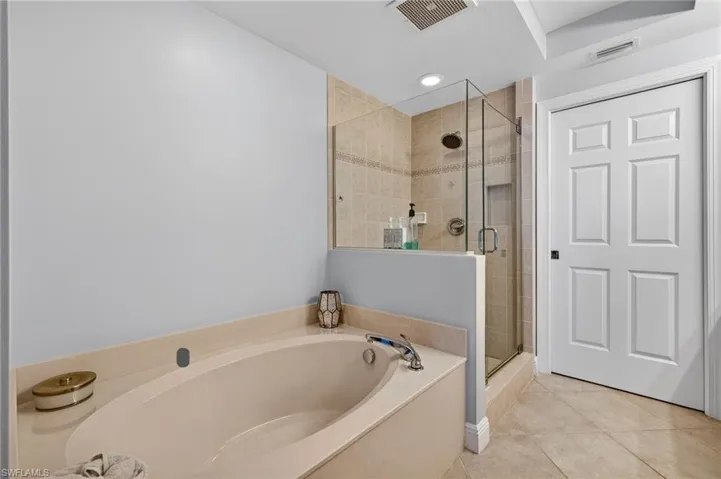 Full bath featuring a bath, a shower stall, light tile patterned floors, and recessed lighting