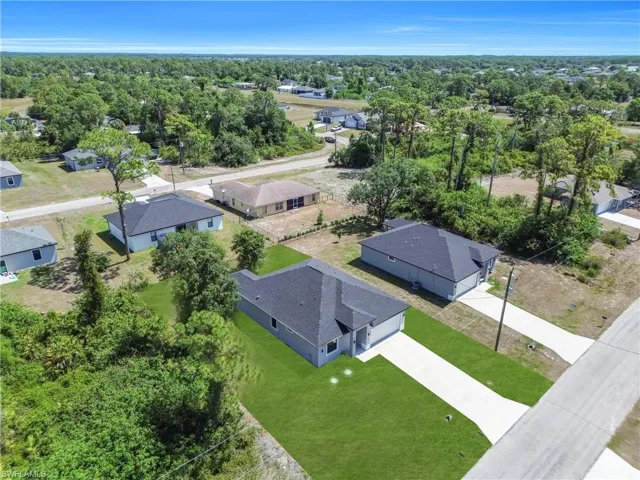 New construction residence featuring a dark shingle roof, light grey exterior siding, and an attached two-car garage