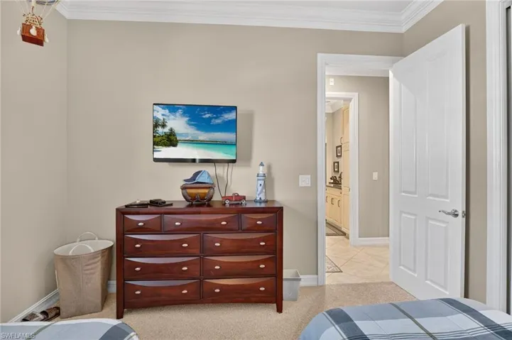 Bedroom featuring crown molding and light carpet