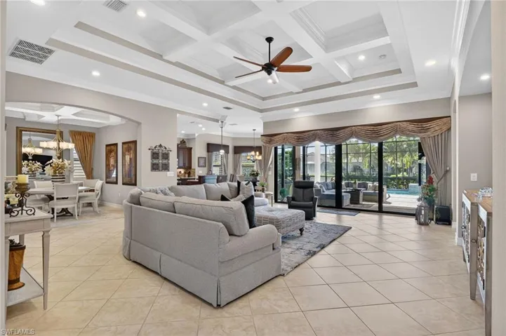 Living area with a chandelier, coffered ceiling, recessed lighting, beam ceiling, and ceiling fan