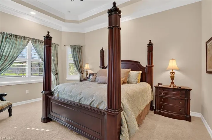 Bedroom featuring crown molding, carpet floors, and a tray ceiling