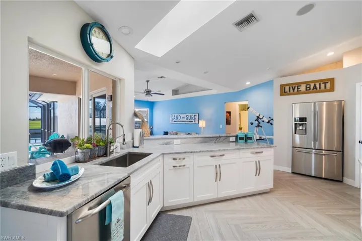 Kitchen featuring sink, stainless steel appliances, kitchen peninsula, and white cabinets