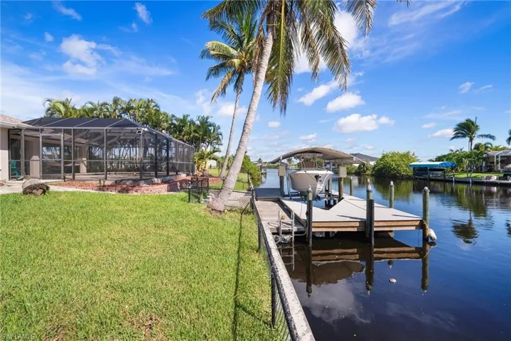 View of dock featuring a yard and a water view