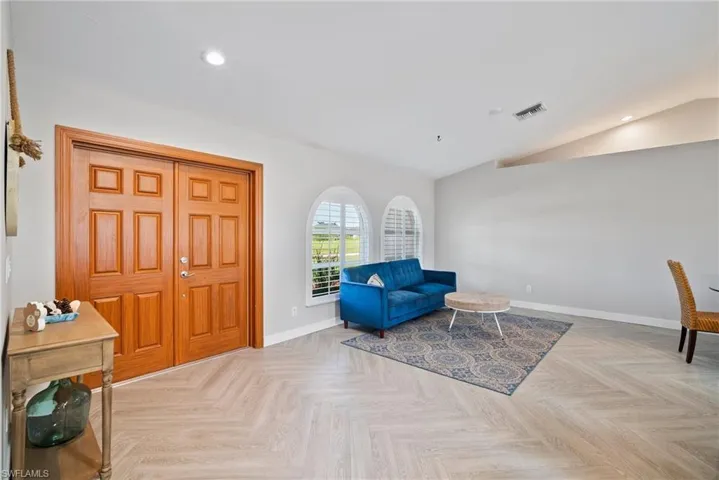 Living area featuring vaulted ceiling and light parquet flooring