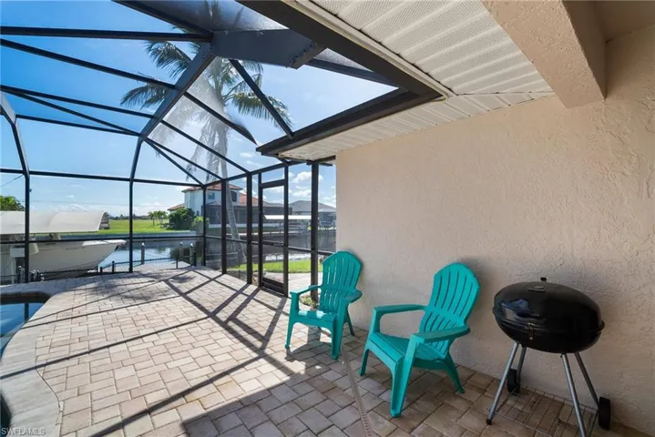 View of patio / terrace featuring a grill, a lanai, and a water view