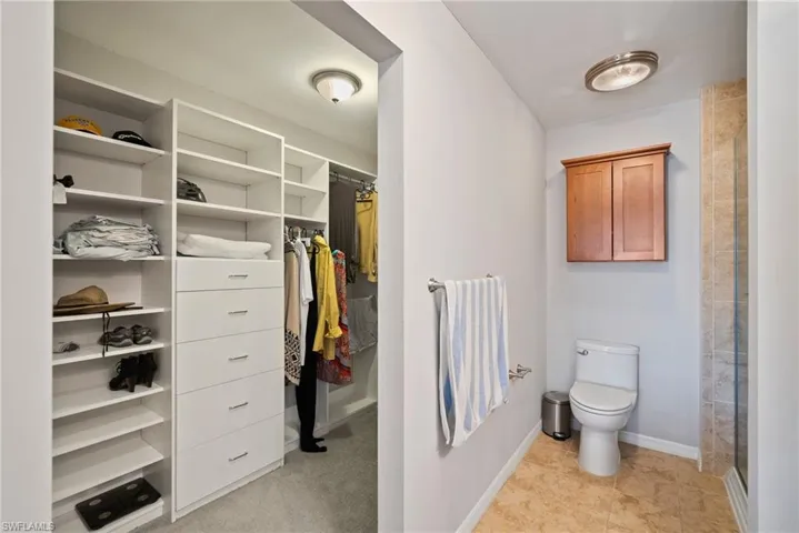 Bathroom with tile patterned floors, a shower, and toilet
