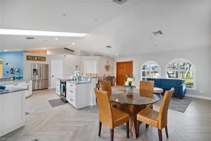 Dining space with vaulted ceiling and light parquet flooring