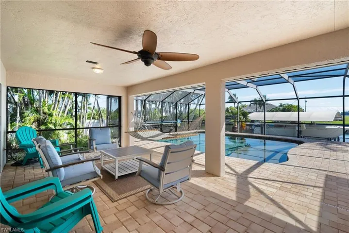 View of swimming pool with a patio, a jacuzzi, an outdoor hangout area, ceiling fan, and glass enclosure