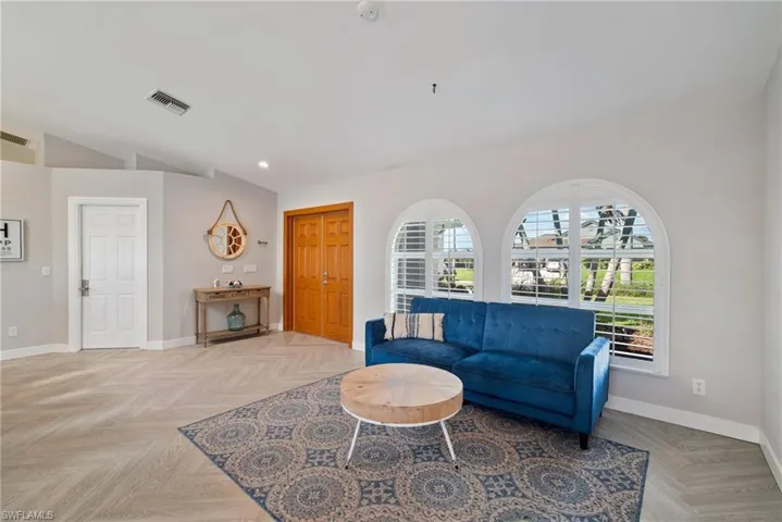 Living room with light parquet flooring and vaulted ceiling