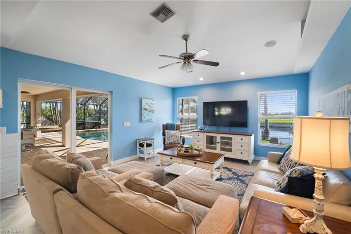 Living room with ceiling fan and light parquet floors