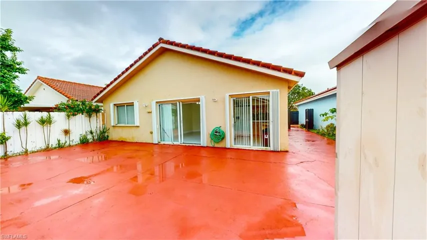 Back of house featuring a patio area, stucco siding, and a tile roof