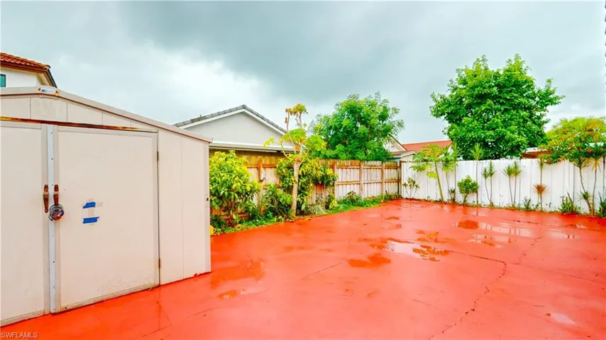 Fenced backyard featuring a shed and a patio area