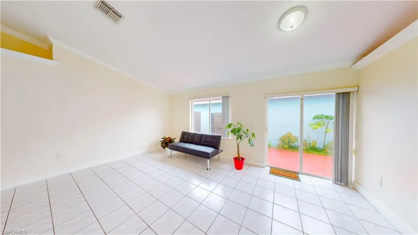 Living area featuring ornamental molding and tile patterned floors