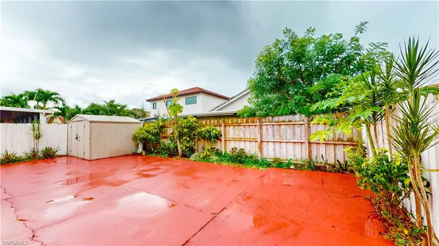 Fenced backyard featuring a shed and a patio