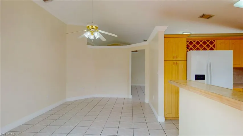 Spare room featuring crown molding, ceiling fan, and light tile patterned floors
